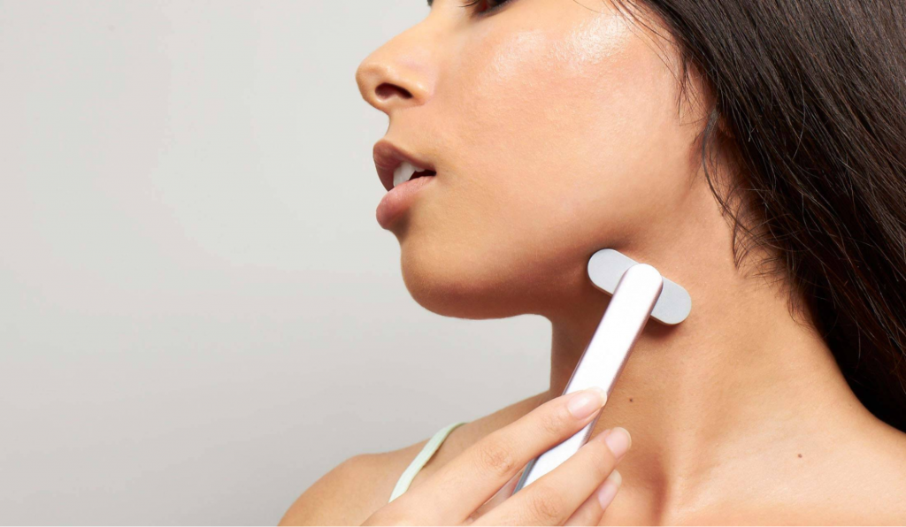 a person uses SolaWave Wand on her neck 