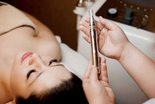 person in a saloon holds microneedling pen